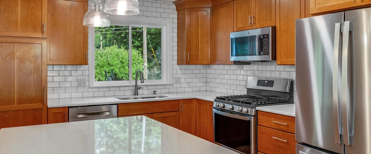 A modern kitchen featuring stainless steel appliances and warm wood cabinets, creating a stylish and functional space