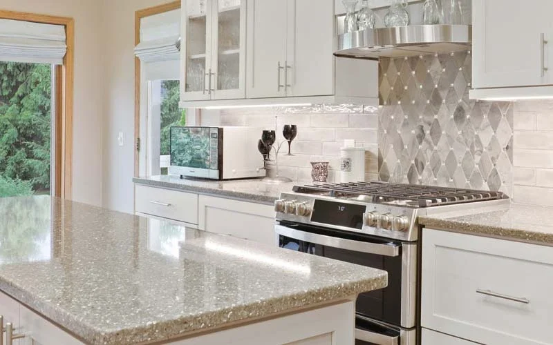 Bright kitchen with sleek white cabinetry and polished granite countertops, highlighting a contemporary design