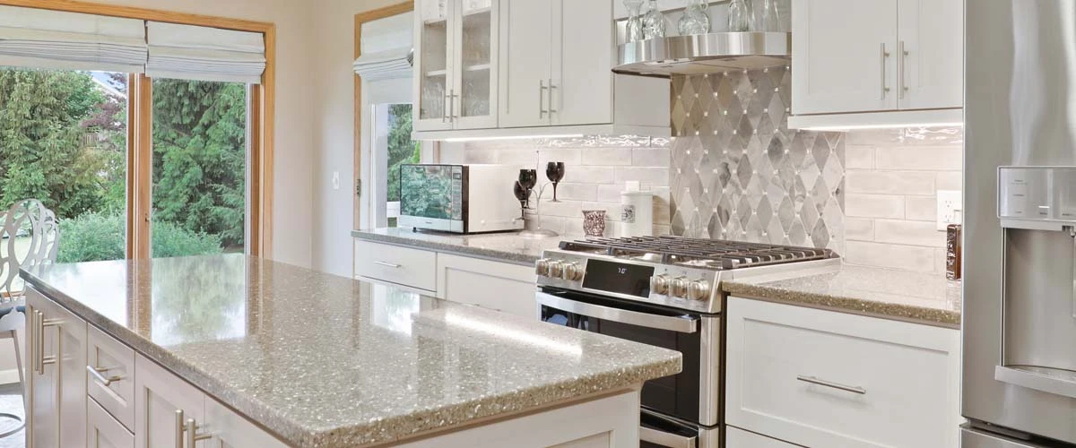 Bright kitchen with sleek white cabinetry and polished granite countertops, highlighting a contemporary design