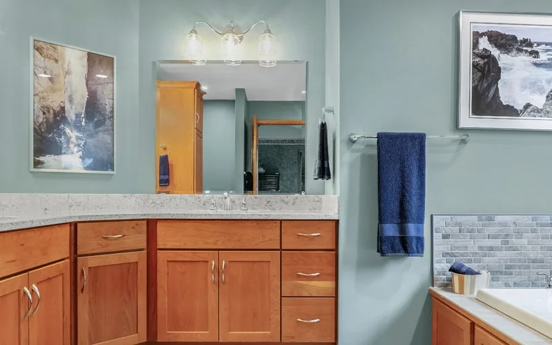 A bathroom featuring blue walls and wooden cabinets, creating a serene and inviting atmosphere.