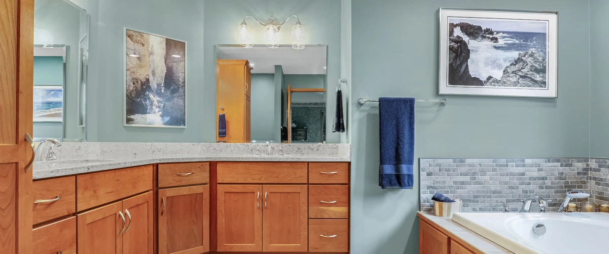 A bathroom featuring blue walls and wooden cabinets, creating a serene and inviting atmosphere.
