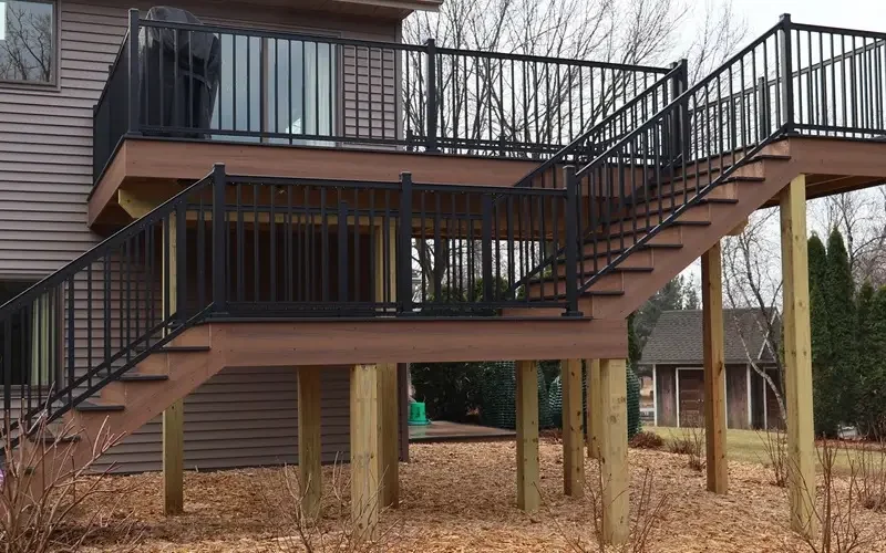 A wooden deck featuring a railing and stairs, designed for a deck replacement project in Wisconsin.