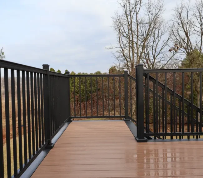 A deck featuring black railings and wooden decking, showcasing a modern outdoor space.